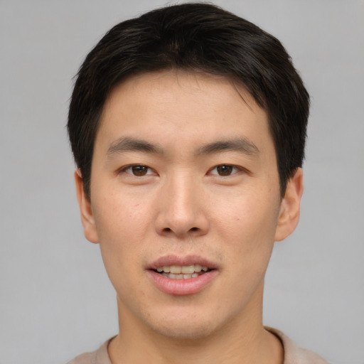 Joyful asian young-adult male with short  brown hair and brown eyes
