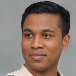 Joyful latino young-adult male with short  black hair and brown eyes