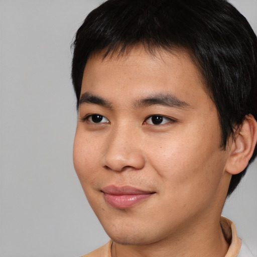 Joyful asian young-adult male with short  brown hair and brown eyes