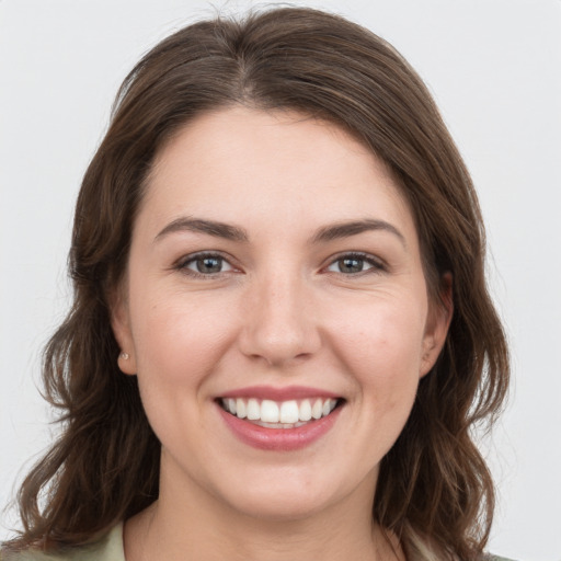 Joyful white young-adult female with long  brown hair and grey eyes