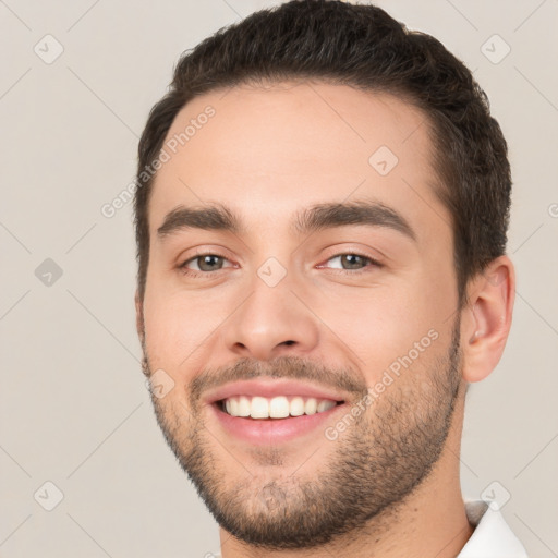 Joyful white young-adult male with short  brown hair and brown eyes