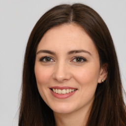 Joyful white young-adult female with long  brown hair and brown eyes