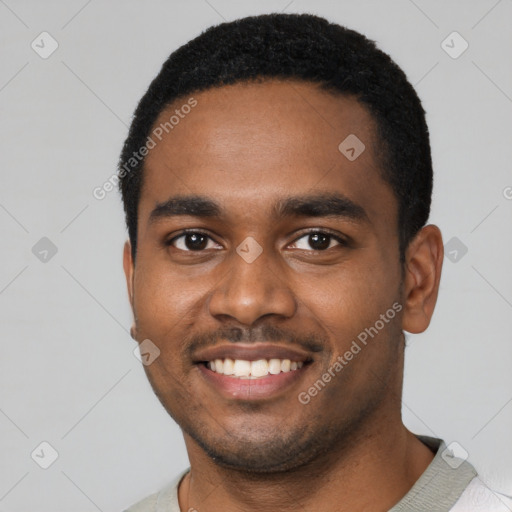 Joyful black young-adult male with short  black hair and brown eyes