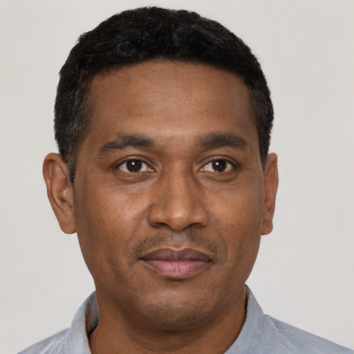 Joyful latino adult male with short  black hair and brown eyes
