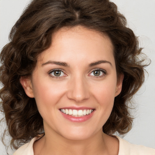 Joyful white young-adult female with medium  brown hair and green eyes