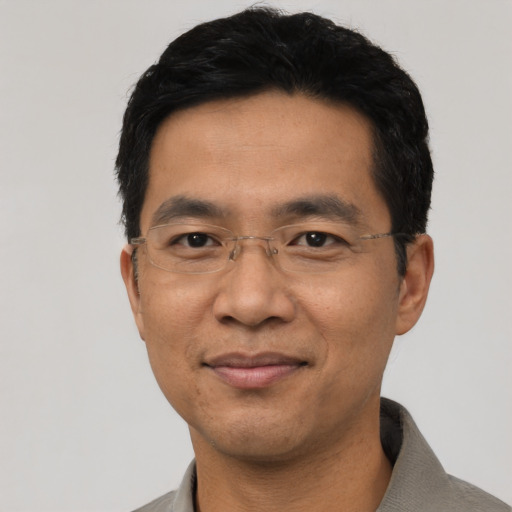 Joyful asian adult male with short  black hair and brown eyes