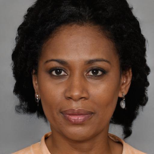 Joyful black adult female with medium  brown hair and brown eyes
