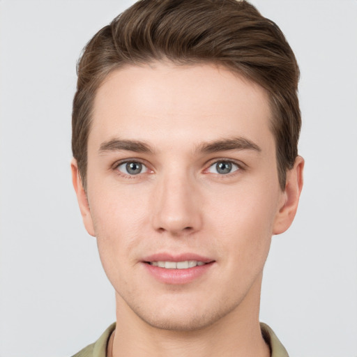 Joyful white young-adult male with short  brown hair and grey eyes