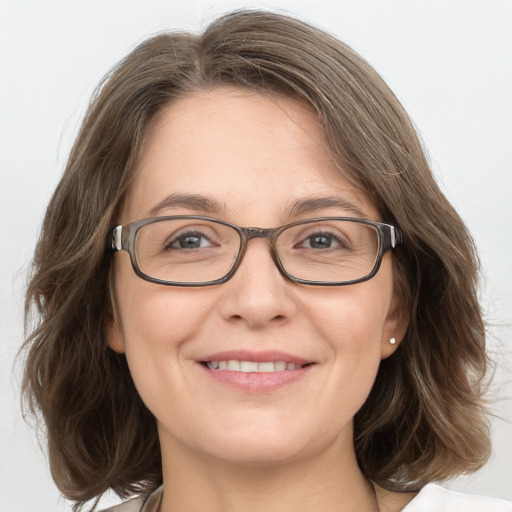 Joyful white adult female with medium  brown hair and grey eyes