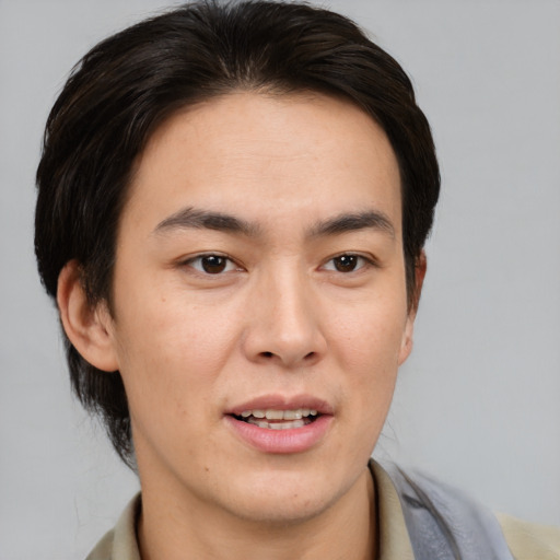 Joyful asian young-adult male with medium  brown hair and brown eyes