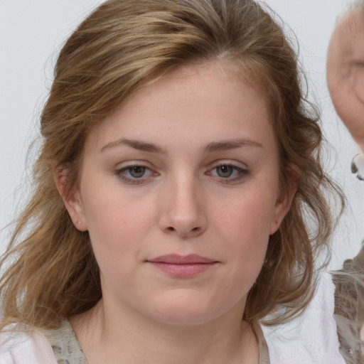 Joyful white young-adult female with medium  brown hair and blue eyes