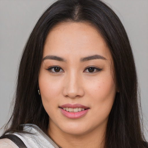 Joyful asian young-adult female with long  brown hair and brown eyes