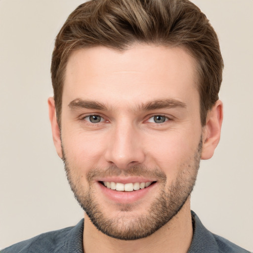 Joyful white young-adult male with short  brown hair and grey eyes