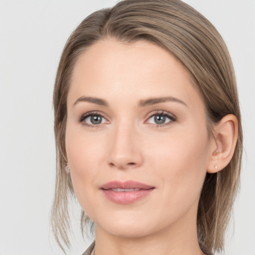 Joyful white young-adult female with medium  brown hair and grey eyes