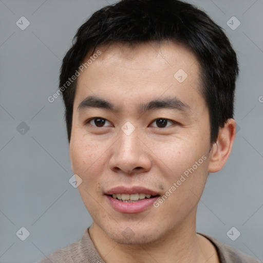 Joyful asian young-adult male with short  brown hair and brown eyes