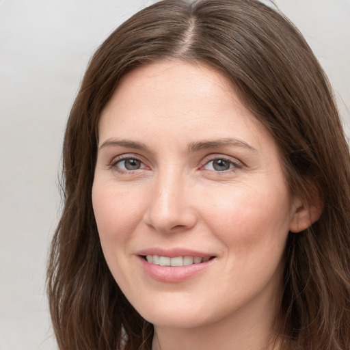 Joyful white young-adult female with long  brown hair and grey eyes