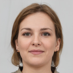 Joyful white young-adult female with medium  brown hair and grey eyes