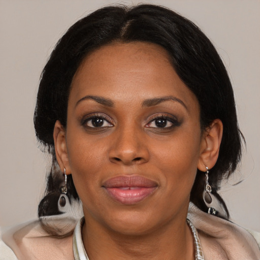 Joyful black young-adult female with medium  black hair and brown eyes