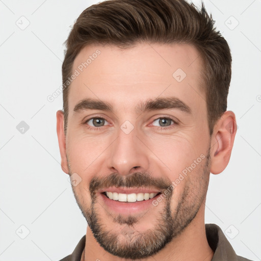 Joyful white young-adult male with short  brown hair and brown eyes