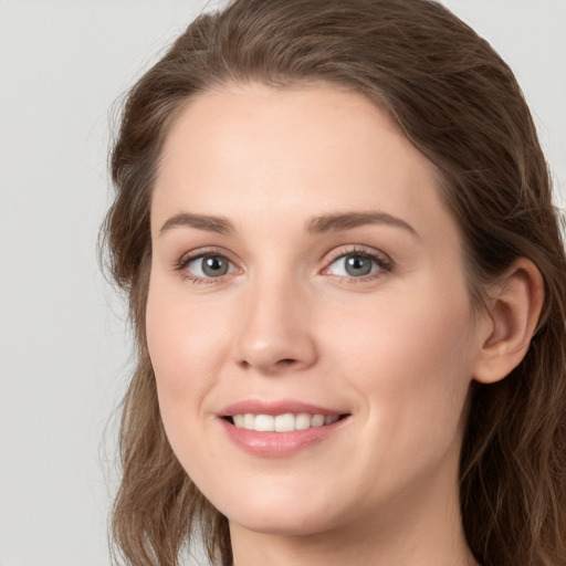 Joyful white young-adult female with long  brown hair and grey eyes