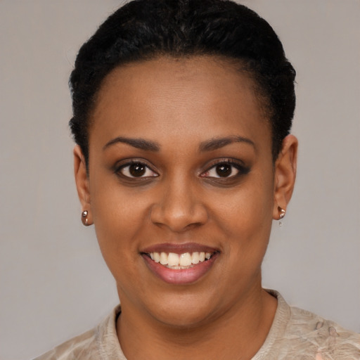 Joyful black young-adult female with short  black hair and brown eyes