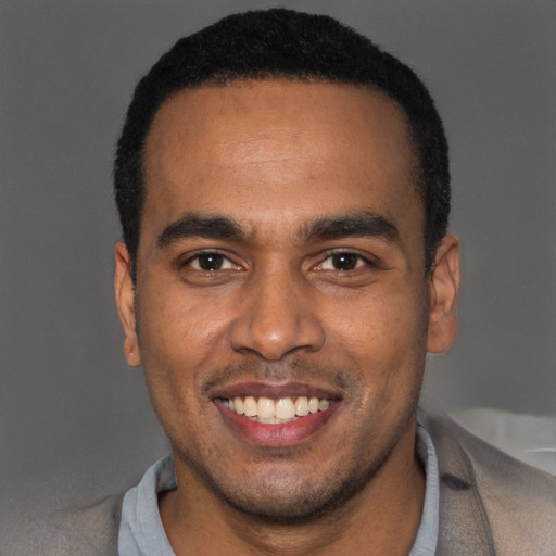 Joyful black young-adult male with short  black hair and brown eyes