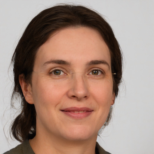 Joyful white adult female with medium  brown hair and green eyes