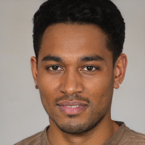 Joyful black young-adult male with short  black hair and brown eyes