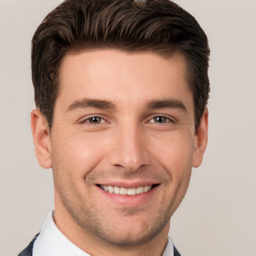 Joyful white young-adult male with short  brown hair and grey eyes