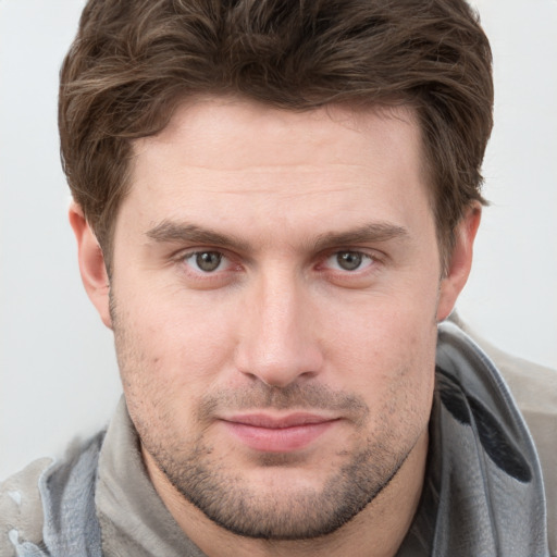 Joyful white young-adult male with short  brown hair and grey eyes