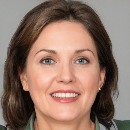 Joyful white adult female with medium  brown hair and blue eyes