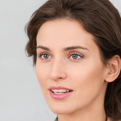 Joyful white young-adult female with medium  brown hair and green eyes