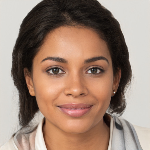 Joyful latino young-adult female with medium  brown hair and brown eyes