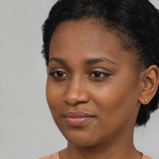 Joyful black young-adult female with short  brown hair and brown eyes