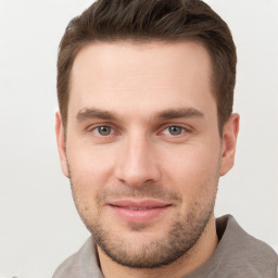 Joyful white young-adult male with short  brown hair and grey eyes