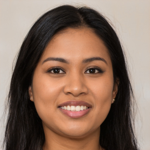 Joyful latino young-adult female with long  brown hair and brown eyes