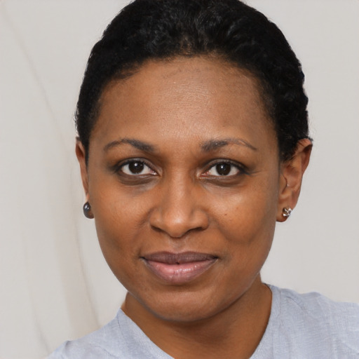 Joyful black adult female with short  black hair and brown eyes