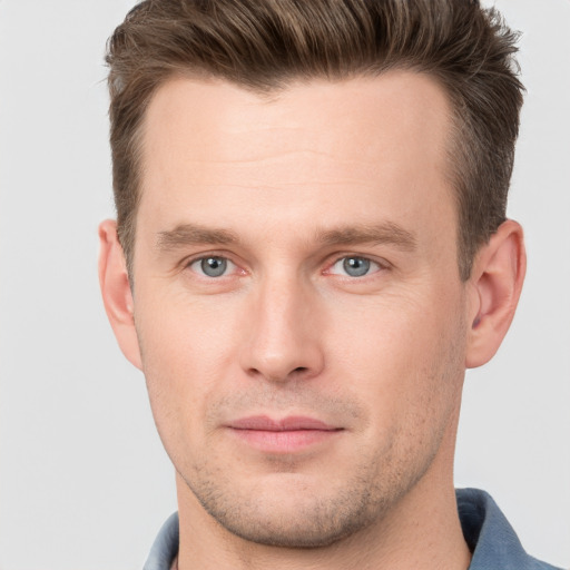 Joyful white young-adult male with short  brown hair and grey eyes