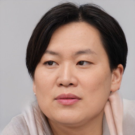 Joyful asian adult female with medium  brown hair and brown eyes
