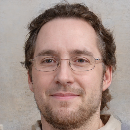 Joyful white adult male with short  brown hair and blue eyes