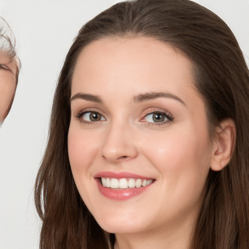 Joyful white young-adult female with long  brown hair and grey eyes