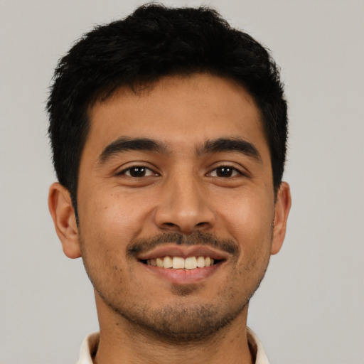 Joyful latino young-adult male with short  black hair and brown eyes