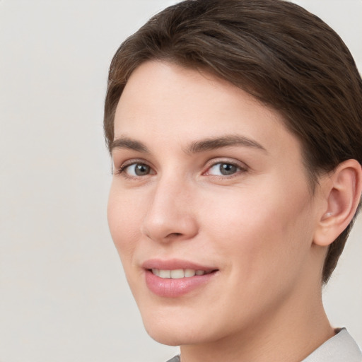 Joyful white young-adult female with short  brown hair and grey eyes