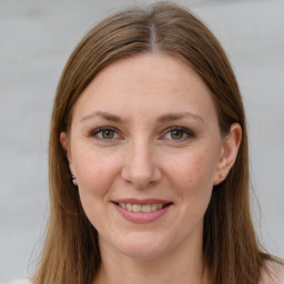 Joyful white adult female with long  brown hair and grey eyes