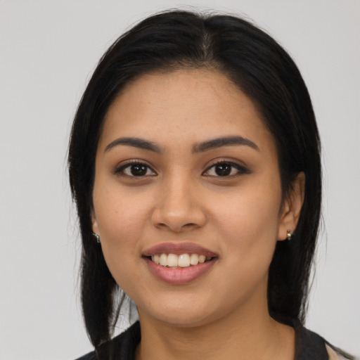 Joyful latino young-adult female with long  black hair and brown eyes
