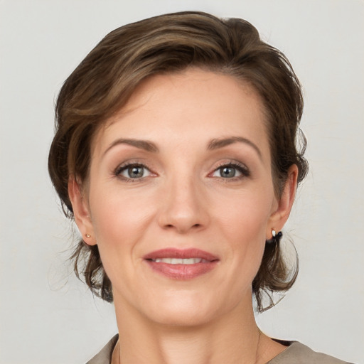 Joyful white young-adult female with medium  brown hair and grey eyes