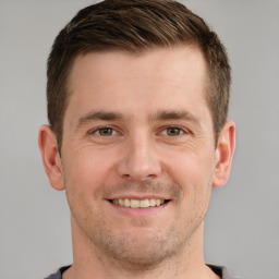 Joyful white young-adult male with short  brown hair and grey eyes