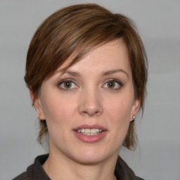 Joyful white young-adult female with medium  brown hair and grey eyes