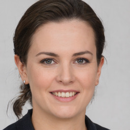 Joyful white young-adult female with medium  brown hair and grey eyes