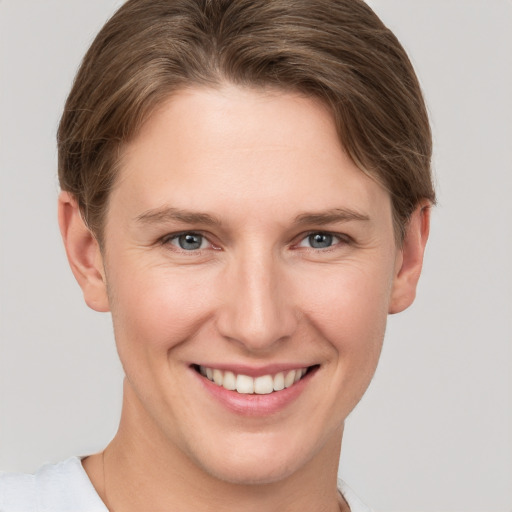 Joyful white young-adult female with short  brown hair and grey eyes